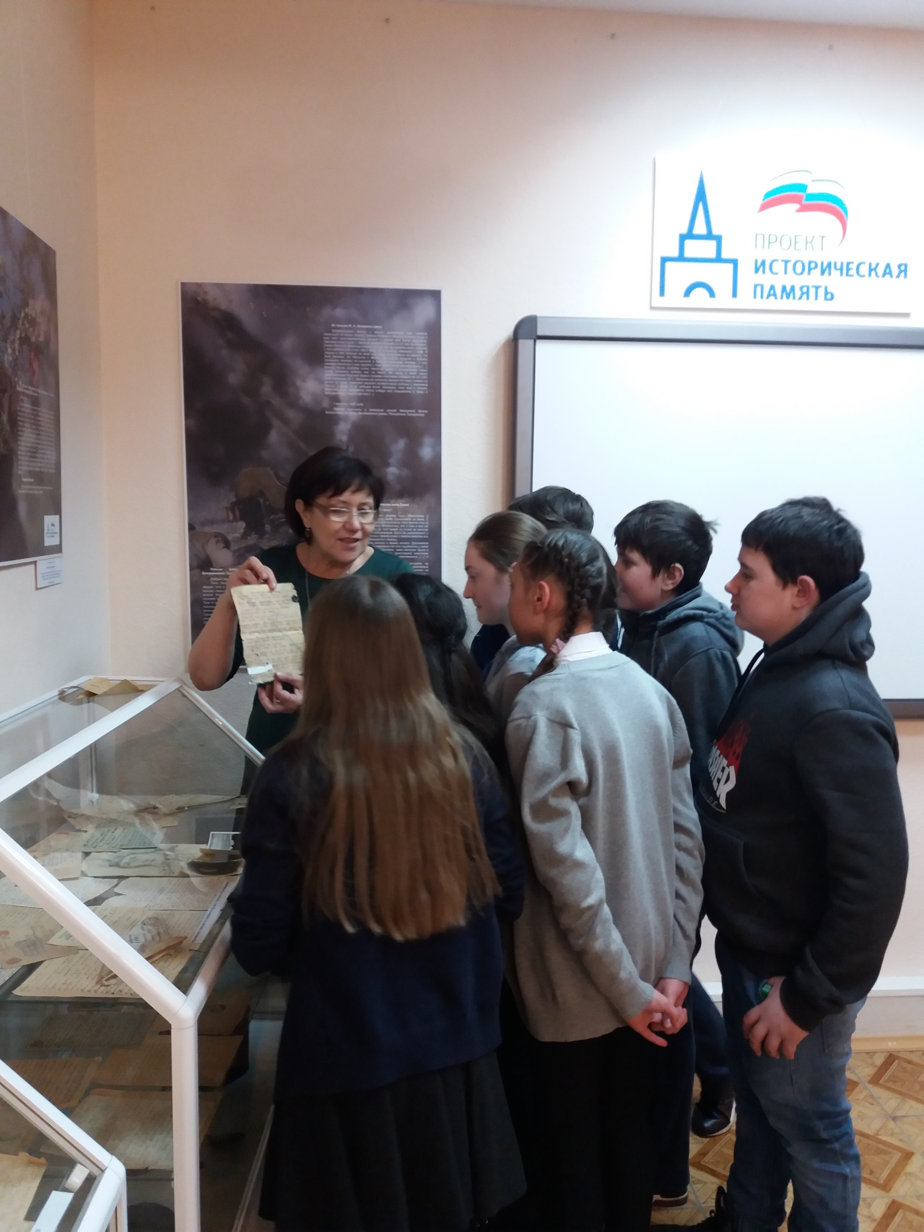 Научный сотрудник ведет экскурсию по выставке.